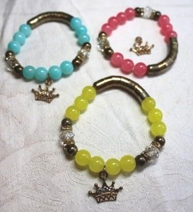 lot 250 image: (3) matching glass bead stretch bracelets with crown charms. Pink, blue and yellow