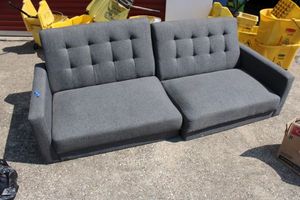 lot 127 image: Grey loveseat (legs are already detached). 2-part loveseat goes together with hinges shown in photos.