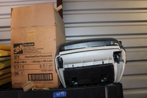 lot 99 image: Commercial paper towel dispenser and box of Scotch 3M Clear sealing tape