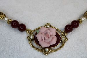 lot 2 image: Signed 1928 Victorian inspired brand pink ceramic rose burgundy enamel and pearl necklace and poststud earring set.16L. Barrel clasp. Has 1928 hang tag. Earrings 2L
