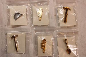 lot 55 image: (6) Construction and tool themed lapel pins on cards. Includes hard hat, wrench, shovel, hammer.