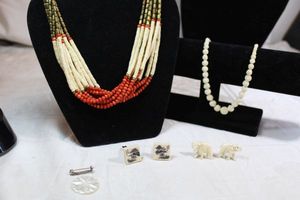 lot 22 image: Ivorybone jewelry. Includes carved graduated bead necklace, tribal style bone necklace, elephant and scenic cufflinks. Includes carved Mother of Pearl vintage brooch.