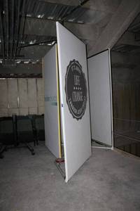 lot 130 image: (4) 12 canvas signs. Has weighted base triangular frame. Frame is Approx. 112H x 27D, Each sign is 5x108.