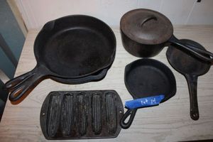 lot 14 image: Cast iron cookware skillets, cornbread mold and pan with lid