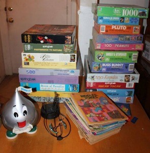 lot 47 image: Generous amount of puzzles, Hersheys Kiss dispenser, and vintage comics.