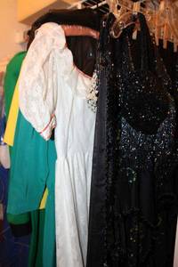 lot 137 image: Glitter and sequence costumes, 1980s dresses, Girl Scout shirt with patches, graduation gown.