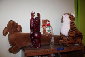lot 142 image: Bookshelf and top items stretching Buddha figurine, plush animal toys