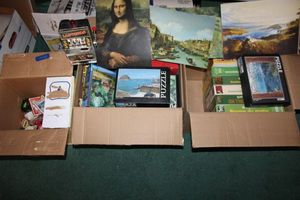 lot 224 image: Puzzles, card decks, slot machine piggy bank, art posters with facts on the back