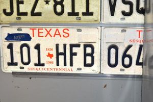 lot 397 image: License plates - TX sesquicentennial, motorcycle, FtW waste hauling, tow truck