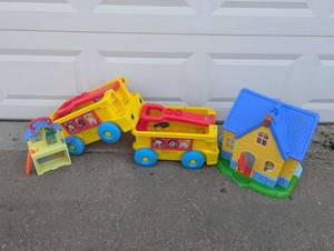 lot 16 image: 4 Piece Toddler Toy Set Includes (2) Fisher Price Little People Build & Pull School Wagons, Disney Doc McStuffins Just Play Doll House, & CoComelon Pop N Play House