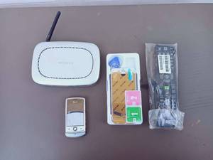 lot 335 image: $$ 4 Piece Technology Mixed Lot - Including Netgear Wireless Router MR814v2, ATT LG Shine CU720 Slider Phone, iPhone 7 LDC Digitizer & Repair Kit, and HP Remote Control