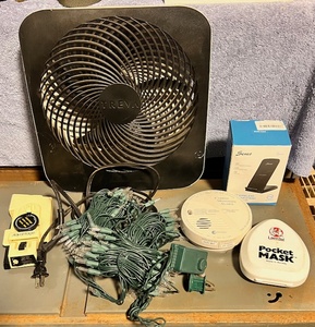 lot 334 image: Mostly Electronic Lot -Including Fan, Travel Iron, Carbon Monoxide Detector, CPR Aide, Phone Charger, New Christmas Lights