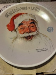 lot 235 image: Norman Rockwell COLLECTOR PLATES BY KNOWLES -SANTA CLAUS  #7606C  WRAPPED UP IN CHRISTMAS  #14893A  SOMEONES UP THERE # 13416E THE BEDTIME STORY  #14788F