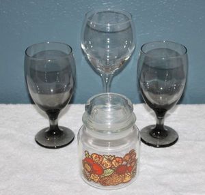lot 43 image: Two Libbys Smokey  Charcoal Goblets, Wine Glass, and Anchor Hocking Nuts and Berries Small Glass Canister