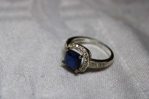 lot 35 image: Sterling Silver  - marked 925 Blue stone surrounded by clear chip beads size 8 weighs 2g