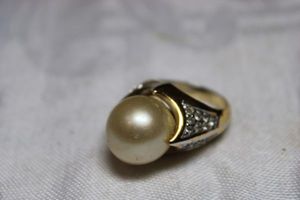 lot 46 image: Sterling Silver - Gold tone ring with pearl marked Ster-Shank, size 7 weighs 14g