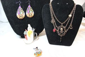 lot 11 image: Halloween jewelry - Wood ghost with cat pin, Pirate skull multichain necklace, Jack O Lantern wire earrings, AJMC enamel with friendly cat on pumpkin