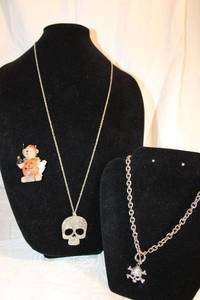 lot 12 image: Halloween jewelry - Skull pendant necklace, Skull and crossbone crystal pendant on chunky chain necklace, and Boyds Bear Brooch with Jack O Lantern costume
