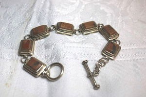 lot 125 image: Sterling Silver - Silver panel station bracelet with brown stones, toggle clasp, each link marked 925, weight 19.3g