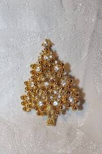 lot 296 image: Signed Eisenberg Ice holiday tree broochpin with clear rhinestones and gold plated mount. Marked Eisenberg. 2H
