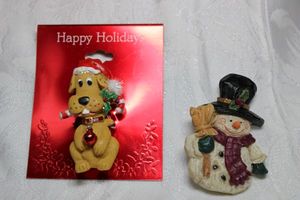lot 272 image: Resin holiday broochespins. Includes gog pin on Happy Holidays card and snowman. Both about 2H
