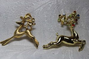 lot 269 image: Signed Dodds (Jewel Creations 1952-1997) reindeer broochpin with crystals. Marked 11 W 30 St No which was the company HQ address used as a mark in 1960s. 2W x 1.5H. Includes a second brushed gold finish reindeer pin 1.75W