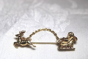 lot 253 image: Signed Avon stick pin with Santa and reindeer. Marked Avon on reverse.