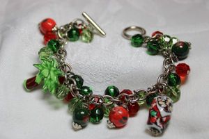 lot 248 image: Red and green faceted glass bead bracelet with tropical Santa and Palm Tree charms. Toggle clasp. 7.5L