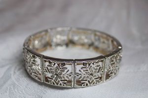 lot 247 image: Crystal accented snowflake metal panel stretch bracelet.