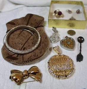 lot 211 image: Misc. jewelry including pendants, brooch Bow pin with Neiman Marcus hang tag, and souvenir spoon marked Meskes Ireland