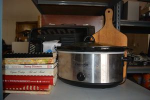 lot 150 image: Kitchen lot Crockpot, recipe books, cutting board and dish rack with plastic gloves