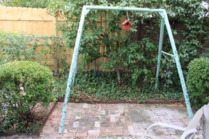 lot 202 image: Metal swing set frame with windchimes