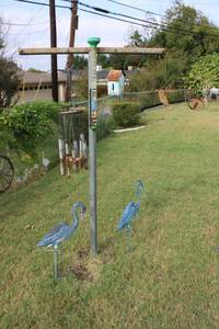 lot 215 image: Yard decorations - wind chime, bird house, metal cranes, rain gauge