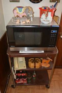 lot 53 image: Panasonic Microwave and cart with contents - Coke bottles, Arners ceramic elephant, and more