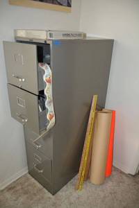 lot 97 image: 4 drawer file cabinet plus schoolcraft supplies. Also includes Louisville Slugger cracked bat, see photos