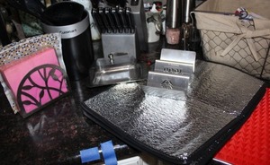lot 73 image: Napkin holder and napkins, Utensil holder and contents, Knife block with contents, Taco holder, thermal sheets, and more (basket not included)