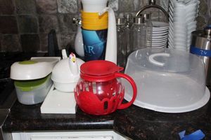 lot 87 image: Plastic cups, cake holder, microwave popcorn maker, Microwave egg cooker, chopper and slicer