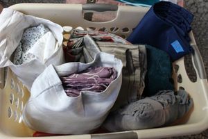 lot 174 image: Basket with contents, includes decorative throw pillow, Sheets full size, dust Ruffle, Curtains and soft teal throw blanket, Curtains, Two peach, grey and white panels, 1 tan panel 38x40 and two blue panels 65x46