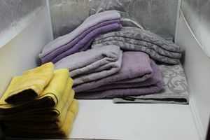 lot 173 image: Towels, barely used, Three Purple and 1 grey and white bath towels, 4 purple and 3 grey and white hand towels, and 4 yellow hand towels and 1 wash cloth