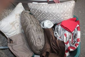 lot 169 image: Basket full of linens, throw pillows, Shower Curtain and Comforter, pillow cases and more