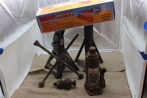 lot 202 image: Jack Stands, 4 way, Bottle jack and drop light and jumper cables, light works off car battery