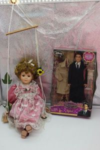 lot 207 image: Dolls Porcelain Doll sitting on a swing, and Disney enchanted Robert doll Factory sealed