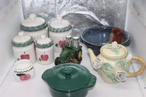 lot 38 image: Vintage Apple Canister Set with Coordination Napkin Holder, Green Ceramic Casserole Dish with Lid, decorative Ceramic tea pot, handmade ceramic bowl and Metal Green Tractor Salt and pepper holder