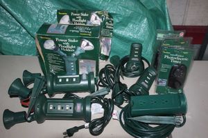lot 19 image: Outdoor Items Flood Lights with Multi Plug (4)s, extension Cords with Multi Plugs and Yard Stakes(5) and Timers all Unused (3)