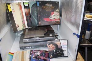 lot 18 image: Panasonic VHS and DVD Player and a record player, along with DVDs and Records and 45s