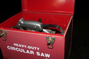 lot 122 image: Black and Decker corded Saw in Heavy Duty Metal Storage Box