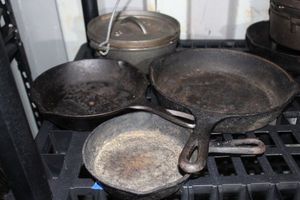 lot 115 image: Various Sizes of Cast Iron Skillets and Small Dutch Oven Pot