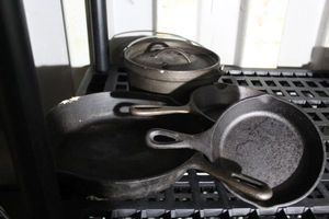 lot 116 image: Various Sizes of Cast Iron Skillets and Small Dutch Oven Pot
