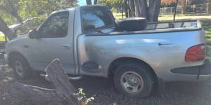 lot 7 image: 2001 Ford F150 Regular Cab, Flare Side, Short Bed, 6 Cylinder, Manual. Clear Title VIN available upon request. No Keys, Must be towed  This was a daily driver until it was parked 3 years .No contents included, Additional time allowed to arrange towing
