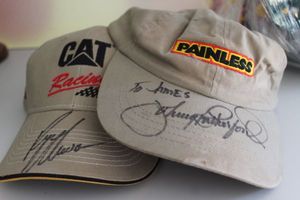 lot 53 image: Two Autographed Baseball Caps Painless, to James, Johnnhy Knoxville and CAT Racing signed by Ryan Newman